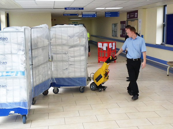 electric tugs moving linen cages in hospital portering 