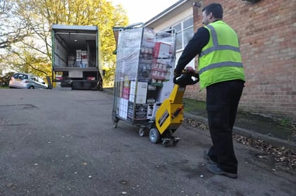 A SmartMover moving a loaded roll cage up a slope towards a tail-lift vehicle