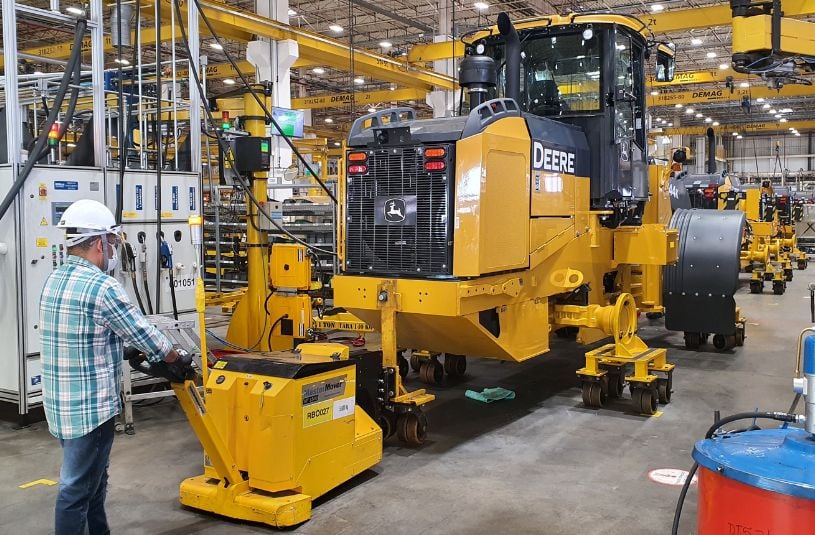 Electric tug moving tractor on assembly line