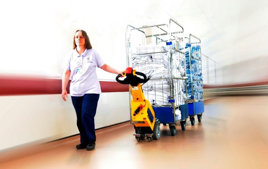 SmartMover SM100+ in a hospital pulling roll cages for facilities management