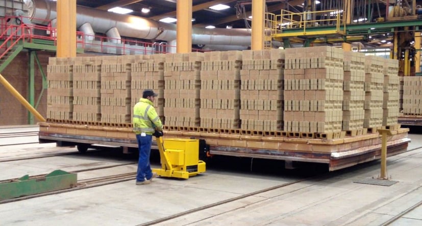 MasterTug déplaçant des briques sur des rails depuis un four