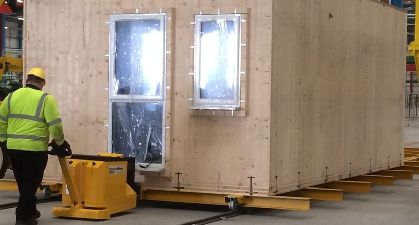 MasterTug moving a modular building frame on rails