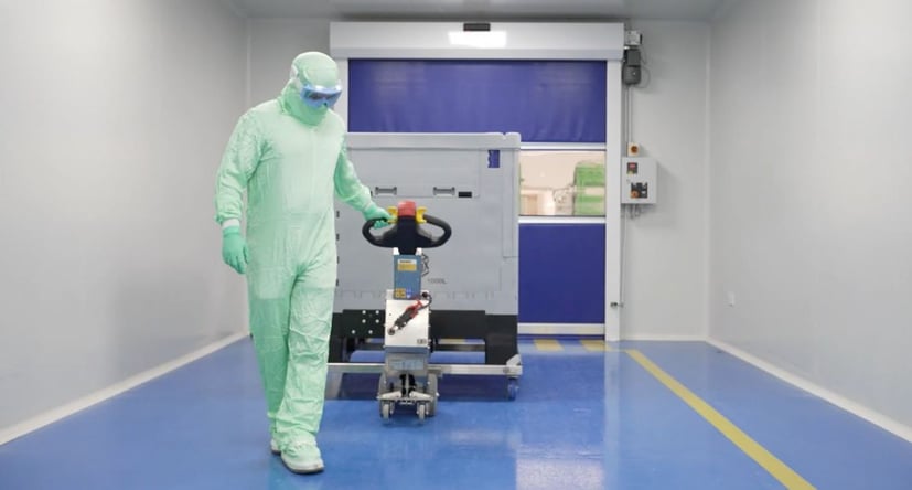 SmartMover SM100+ in Edelstahlausführung bewegt einen Container durch einen Korridor