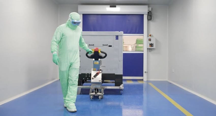 Pharma Mitarbeiter zieht eine Last mit einem SmartMover Edelstahl Elektroschlepper